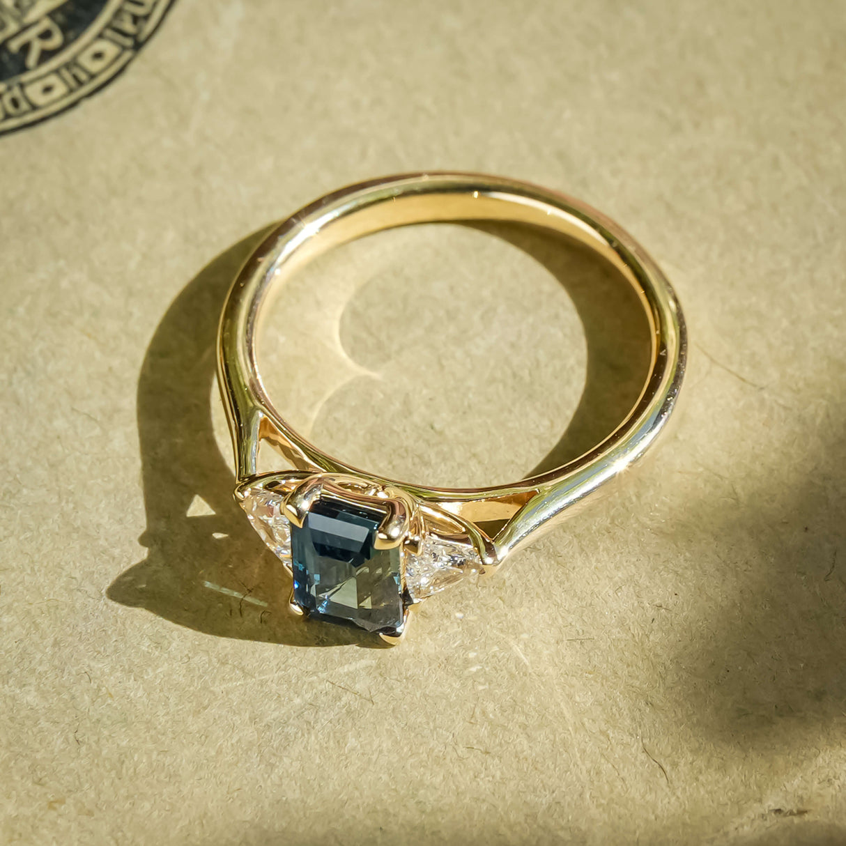 Teal sapphire and diamond three stone engagement ring in classic yellow gold setting