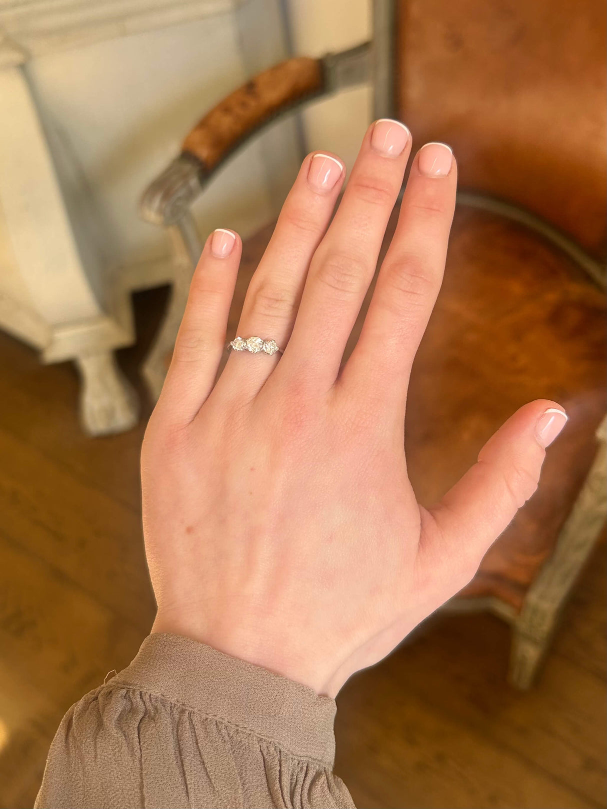 Vintage 1950s diamond three stone ring in white gold on hand.