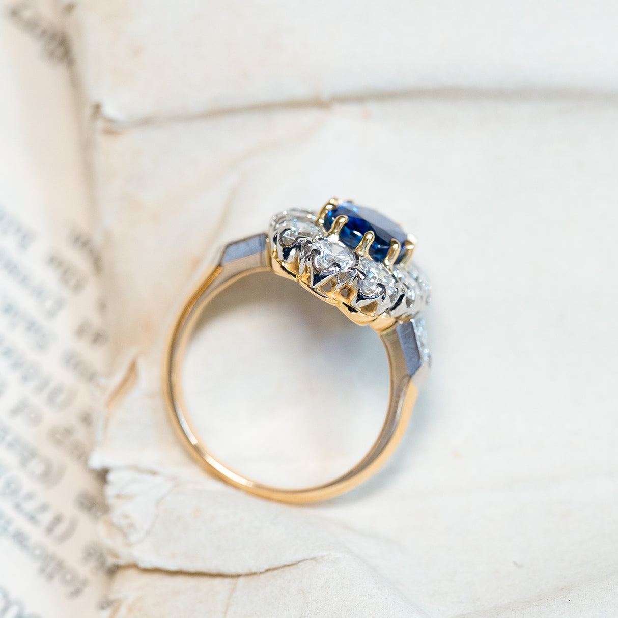 Vintage 1960s French sapphire and diamond cluster ring showing open gallery setting and diamond shoulders.