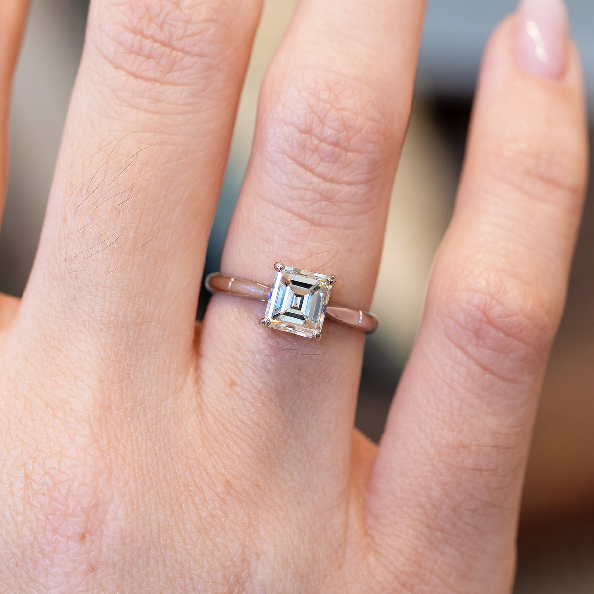 Vintage solitaire diamond ring with emerald-cut diamond and fine band.