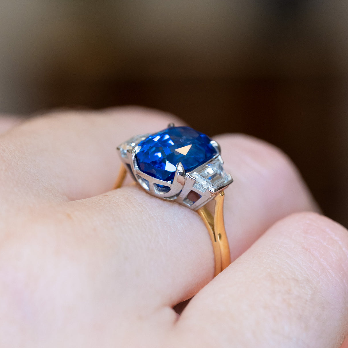 Vintage 1990s sapphire and diamond three-stone ring with structured setting and geometric diamond shoulders.