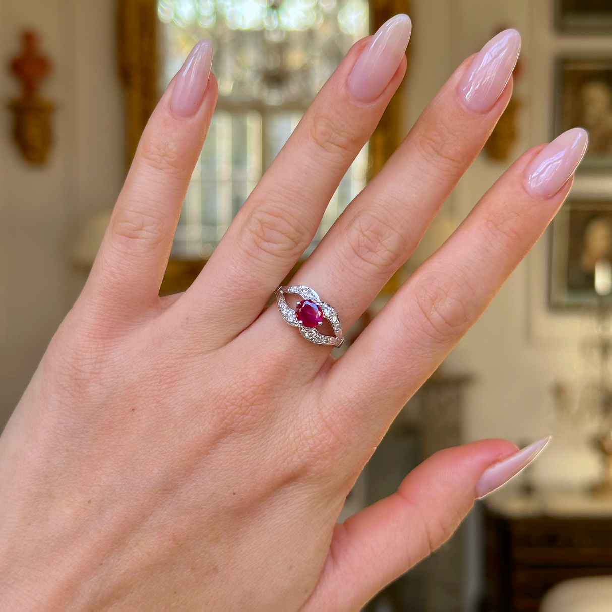 Vintage art deco ruby and diamond ring worn on hand.