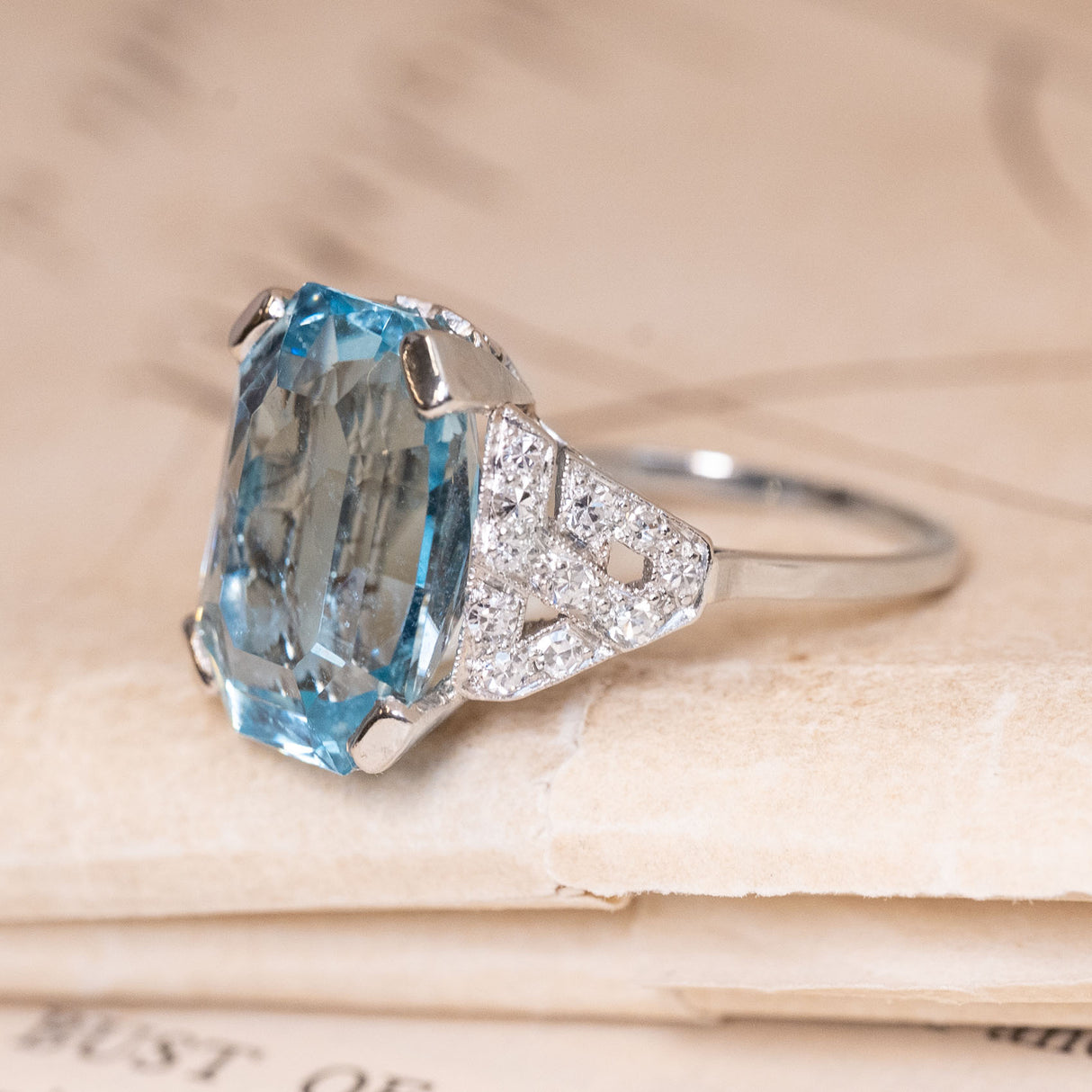 Vintage aquamarine and diamond cocktail ring with a substantial emerald-cut aquamarine and intricate diamond-set geometric shoulders.