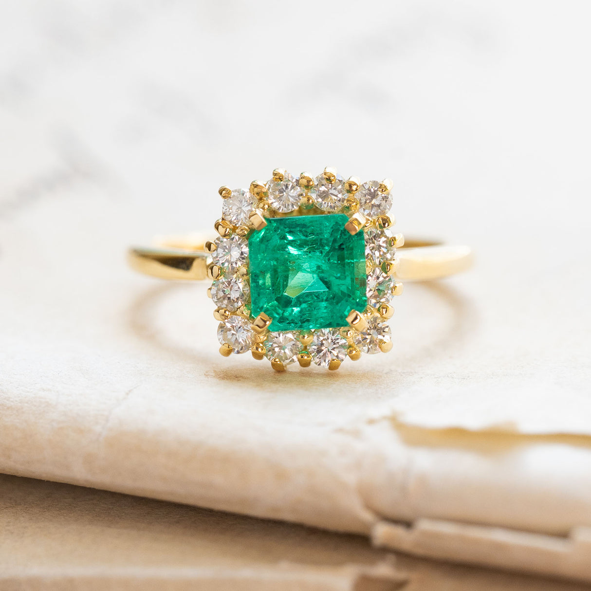 Vintage 1980s Colombian emerald and diamond cluster ring in yellow gold.