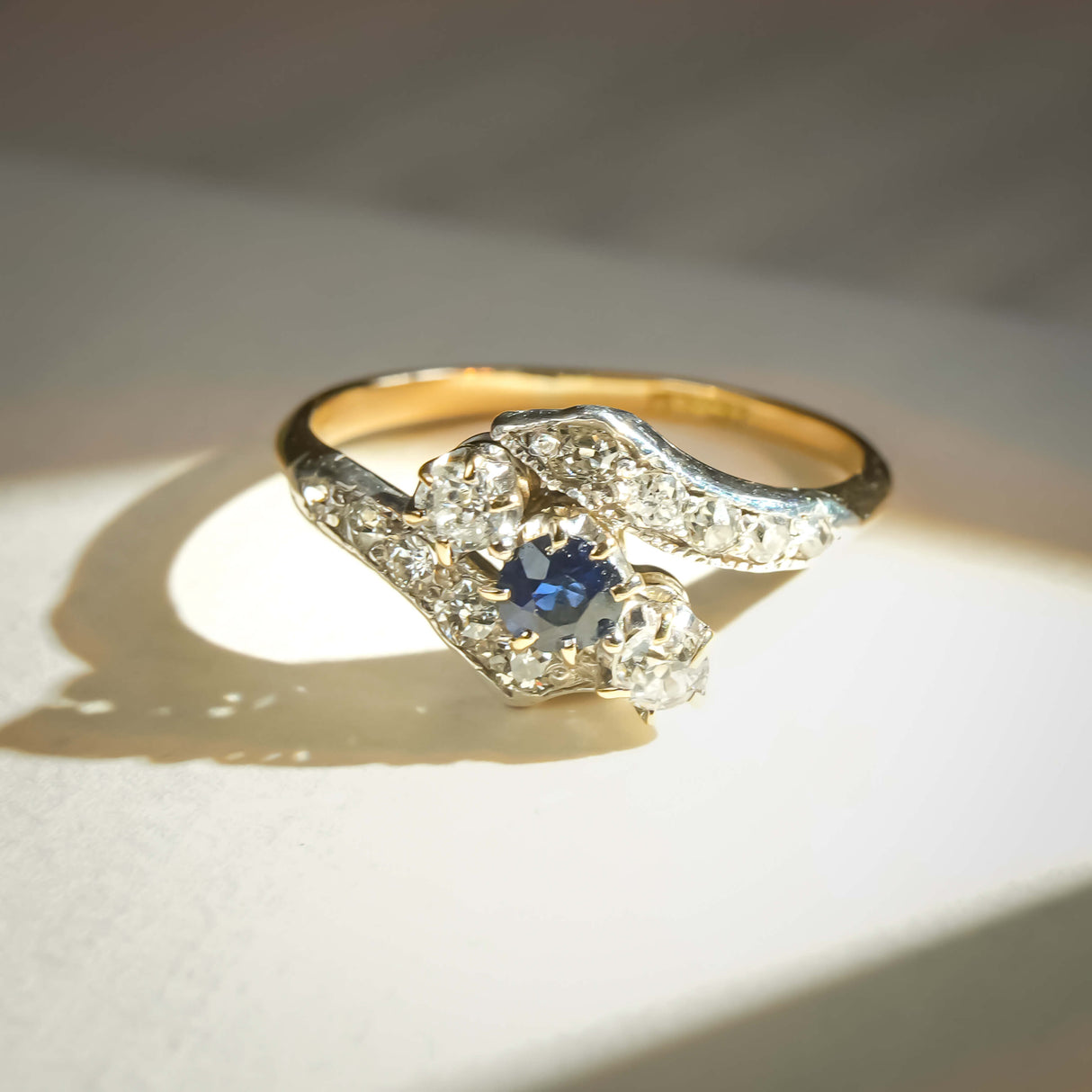 Vintage Edwardian sapphire and diamond twist ring with blue gemstone and diamond accents