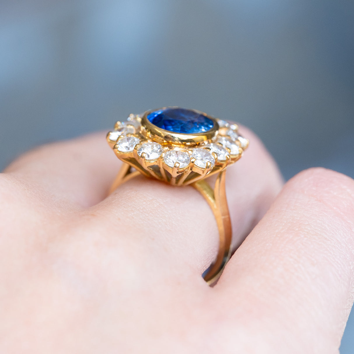 Vintage 1960s French sapphire and diamond cluster ring with elevated gold gallery and oval sapphire centre.