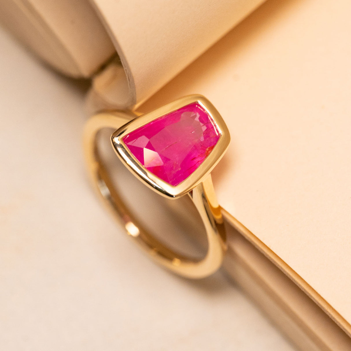 Pink ruby solitaire ring showcasing a vibrant pink gemstone set in polished yellow gold.