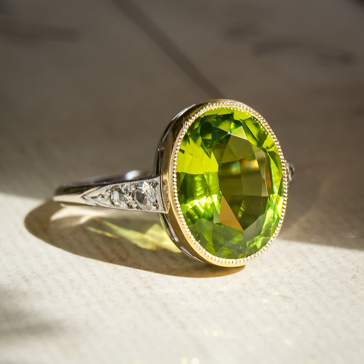 Vintage Art Deco peridot ring with oval green gemstone and diamond accents