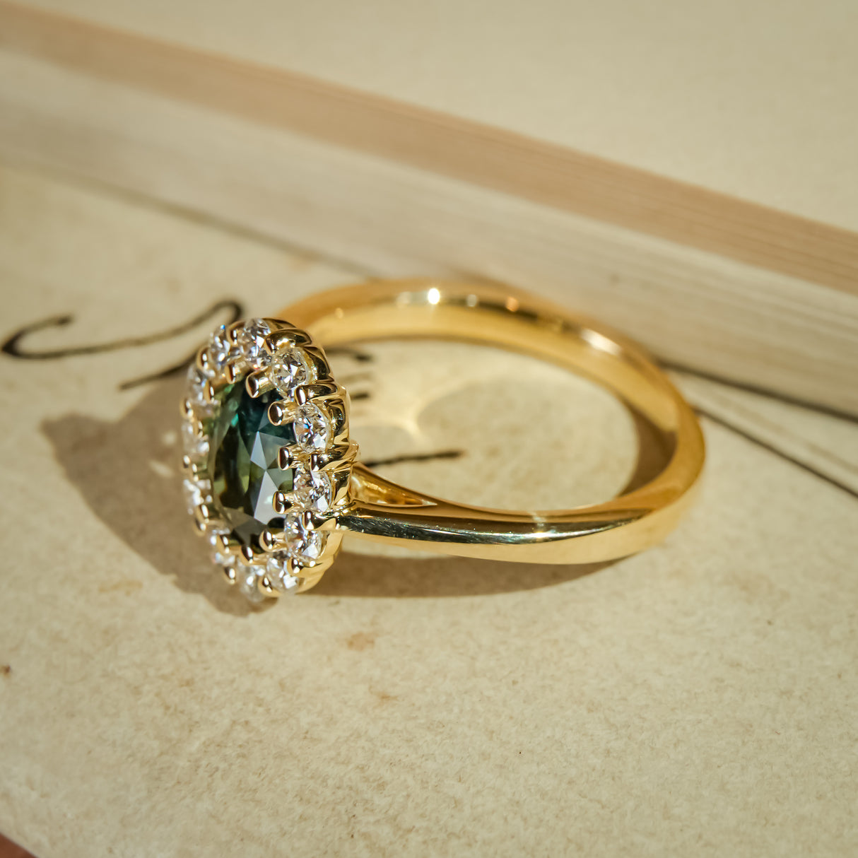 Vintage style green sapphire engagement ring with diamond cluster halo
