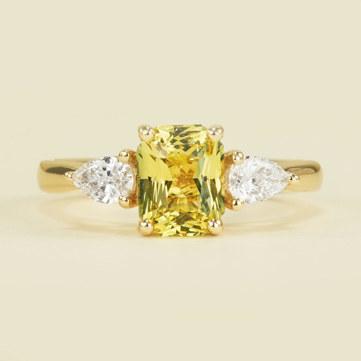 Emerald-cut yellow sapphire and diamond three-stone ring