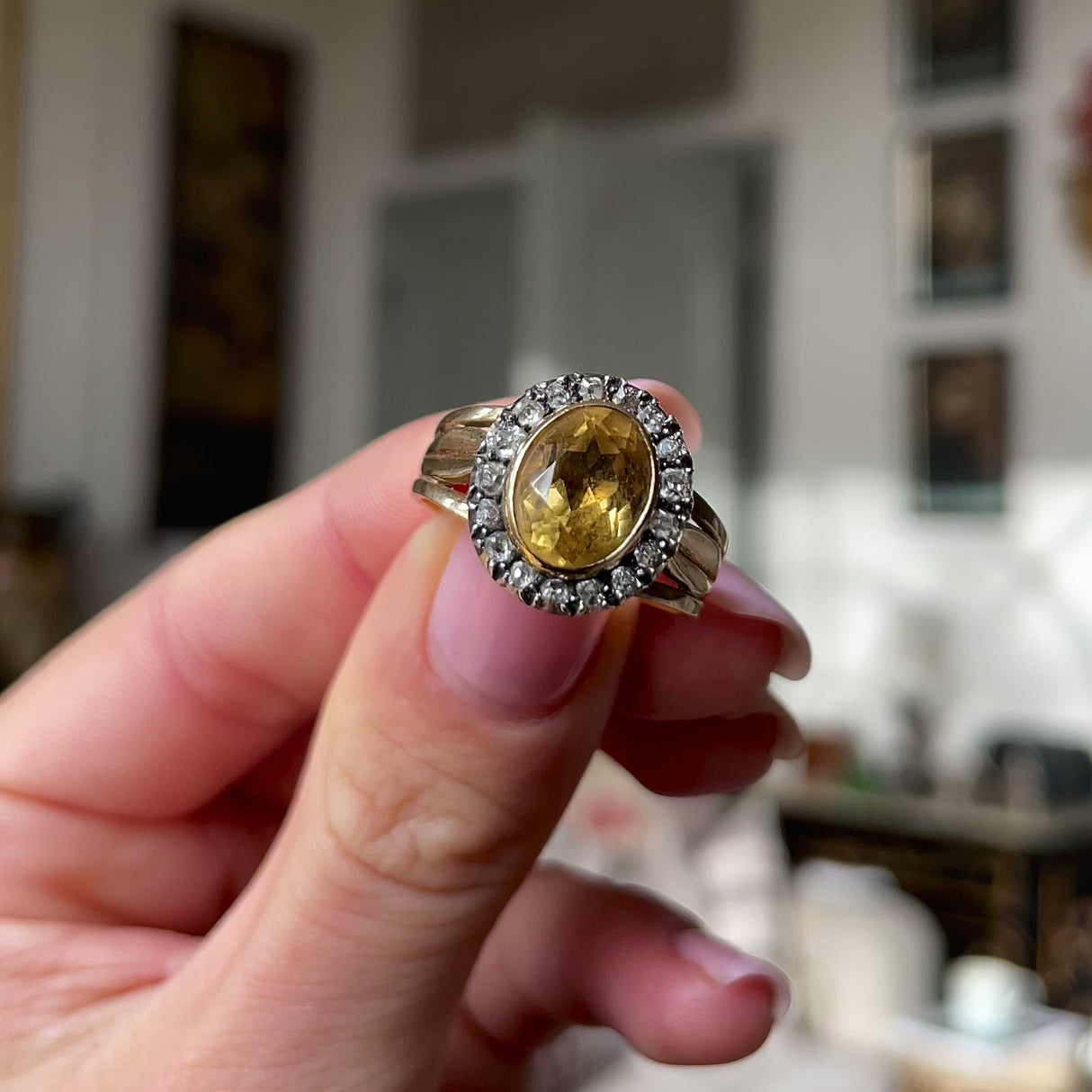Antique Georgian citrine and diamond cluster ring, held in fingers and rotated to give perspective.