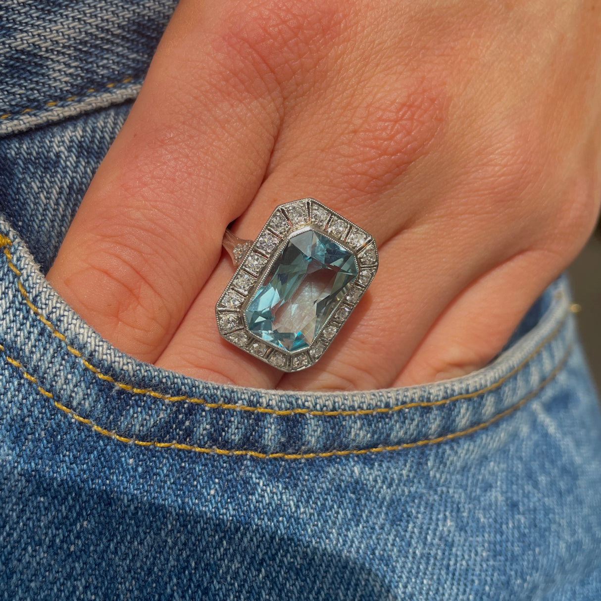 Art Deco aquamarine and diamond cluster ring, worn on hand in pocket of jeans.