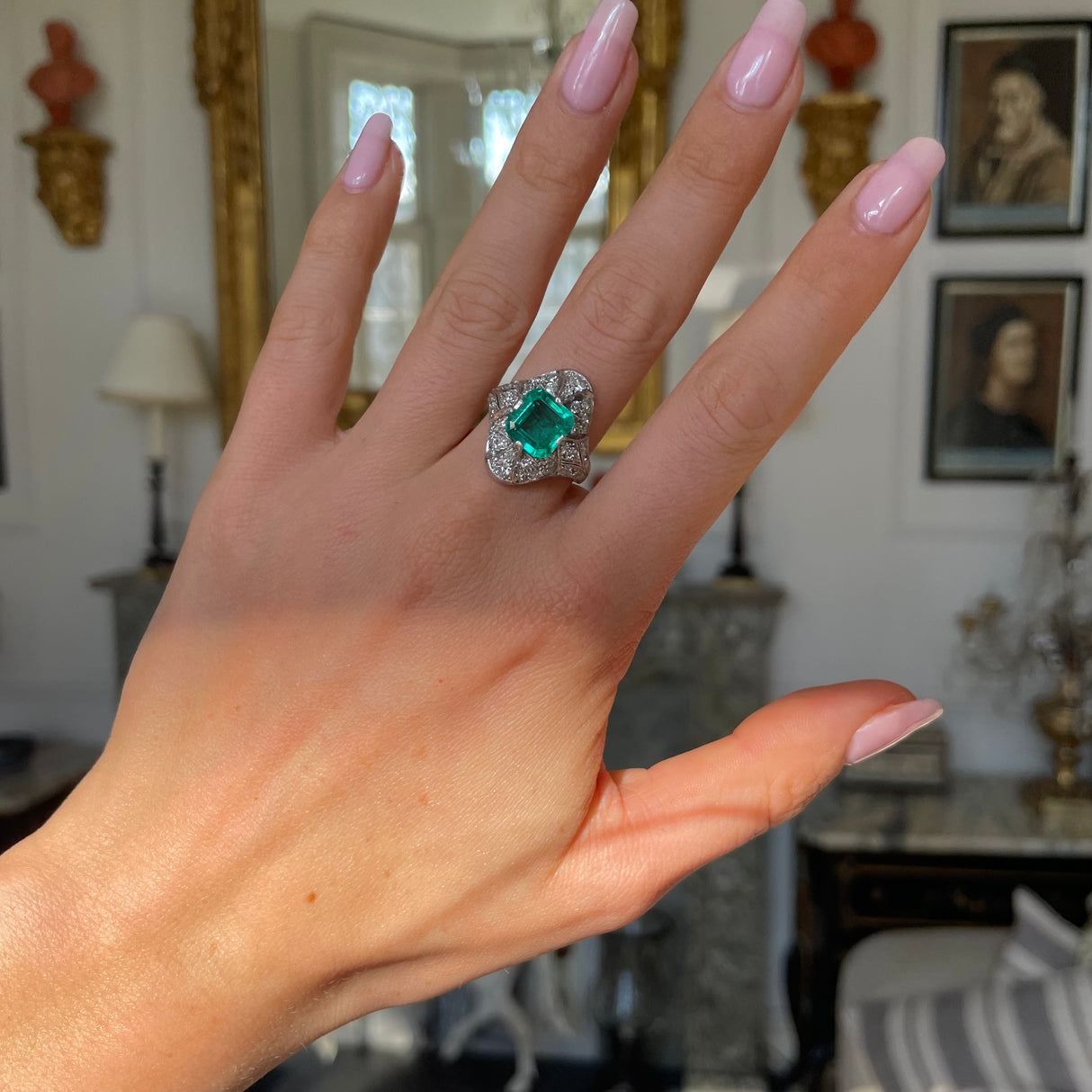 Art Deco emerald and diamond ring, worn on hand.