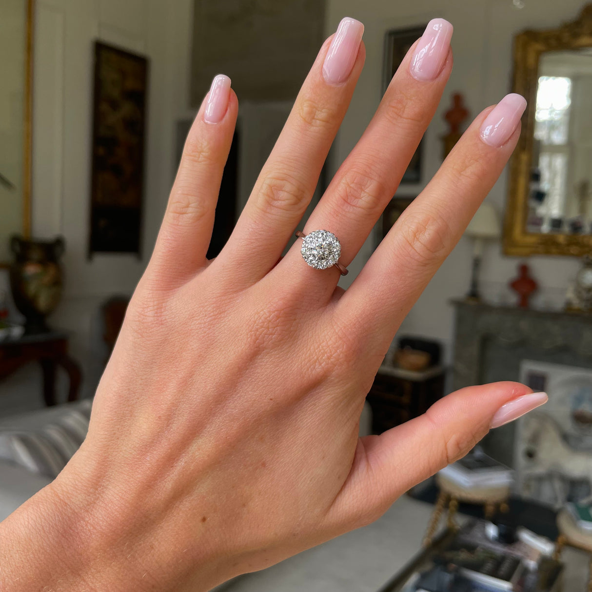 Vintage Art Deco white gold diamond cluster engagement ring, worn on hand.