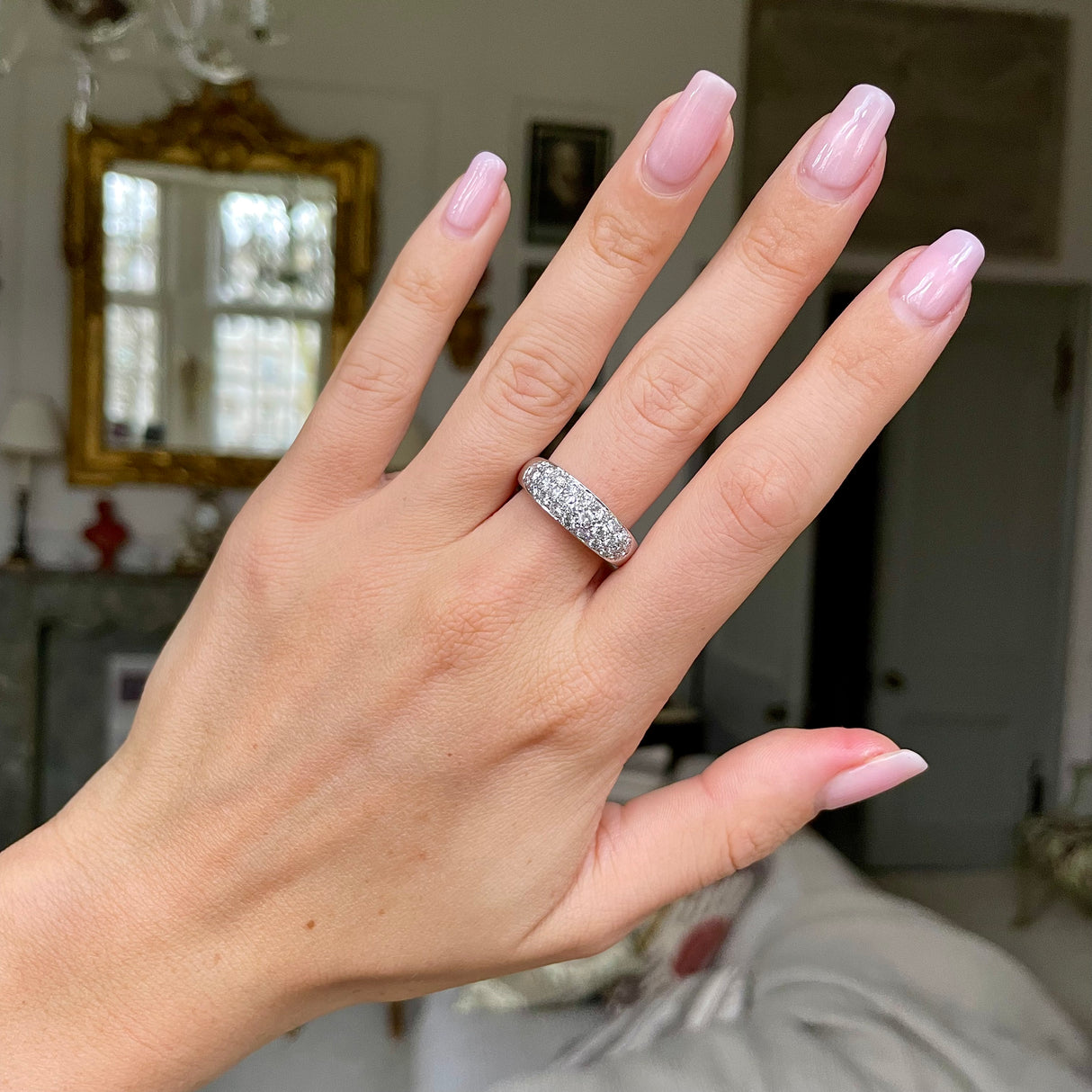 Diamond set platinum band worn on hand.