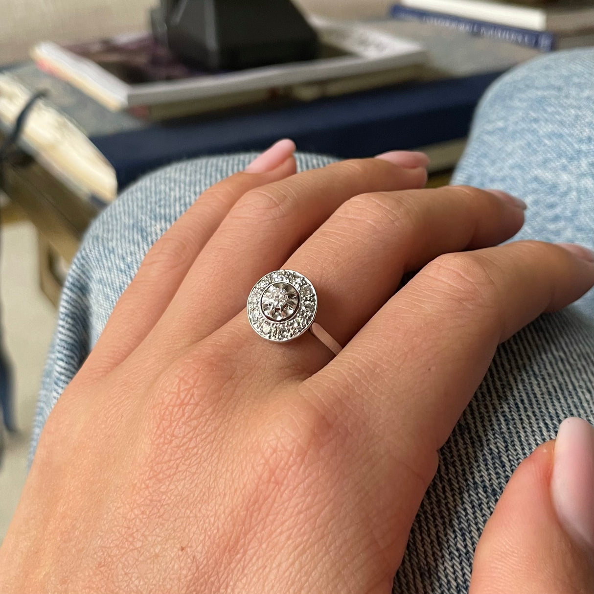 Art Deco diamond cluster engagement ring, worn on hand.