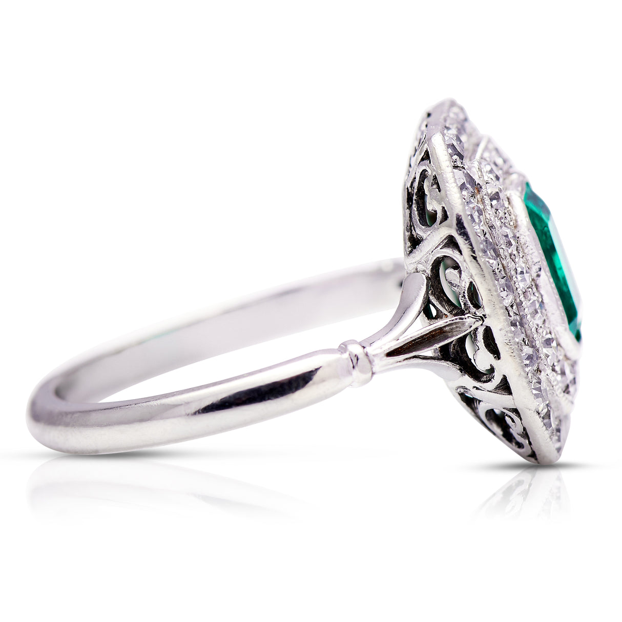 Vintage emerald and diamond cluster ring, side view.