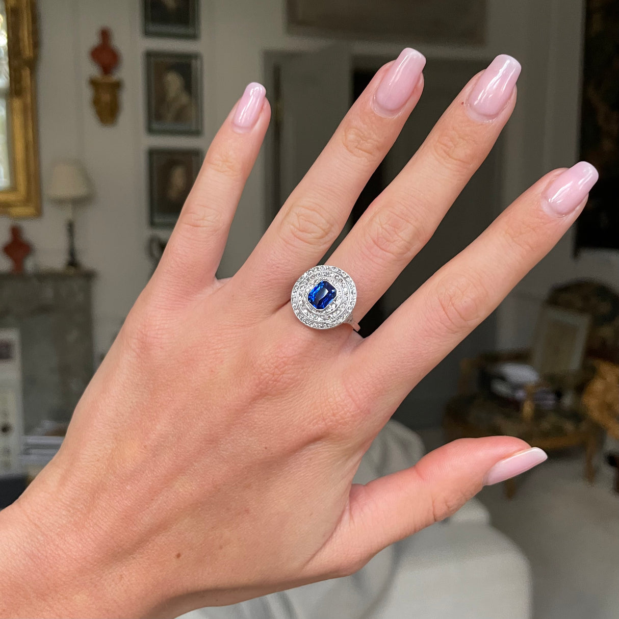 Sapphire and diamond target cluster ring, worn on hand.
