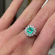 Edwardian emerald and diamond cluster ring, worn on hand and rotated to give perspective.
