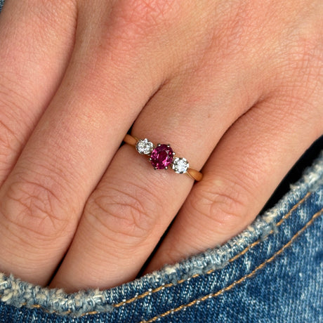 Antique, Edwardian ruby & diamond three-stone ring worn on hand.