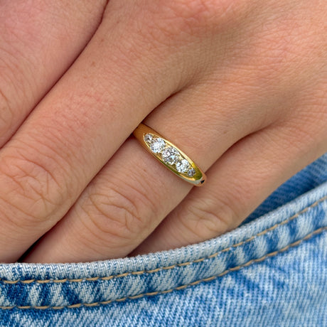 Antique, Edwardian five-stone diamond ring front on hand.