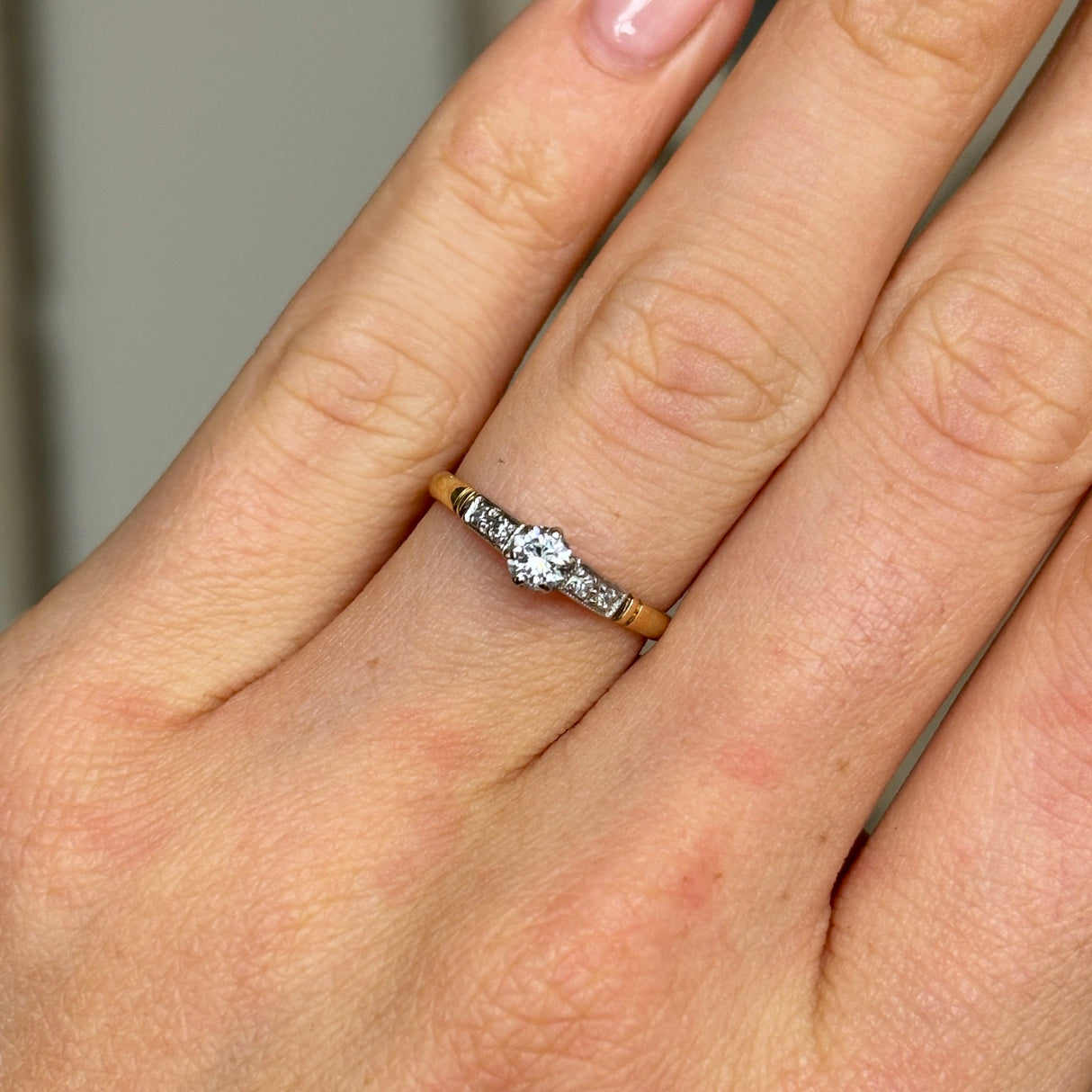 Antique, Edwardian solitaire diamond ring worn on hand.