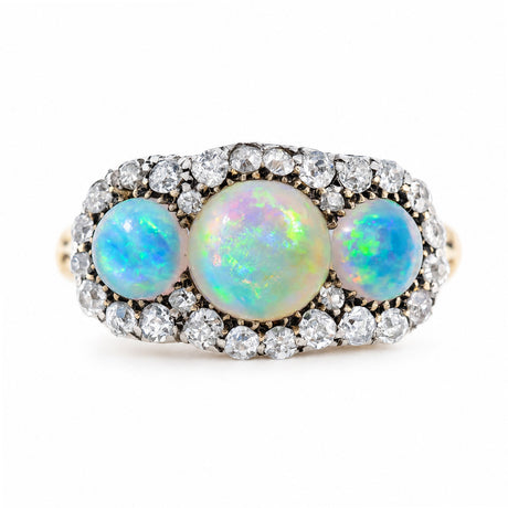 An antique, Victorian three-stone opal & diamond cluster ring with a rub-over setting and yellow gold band.