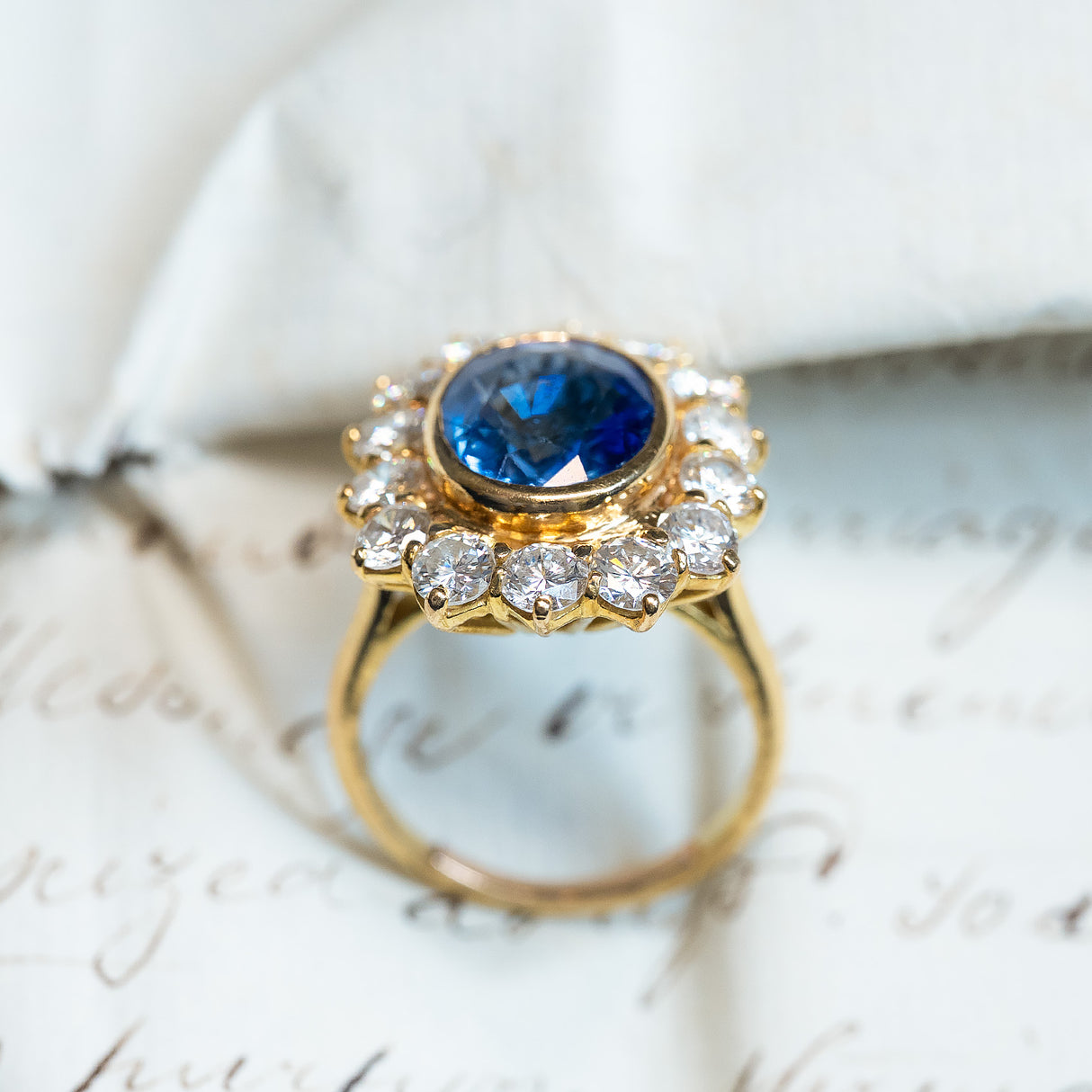 Vintage 1960s French sapphire and diamond cluster ring with elevated diamond-set gallery and oval sapphire centre.