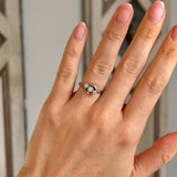 Antique, Edwardian three-stone diamond twist ring worn on hand.