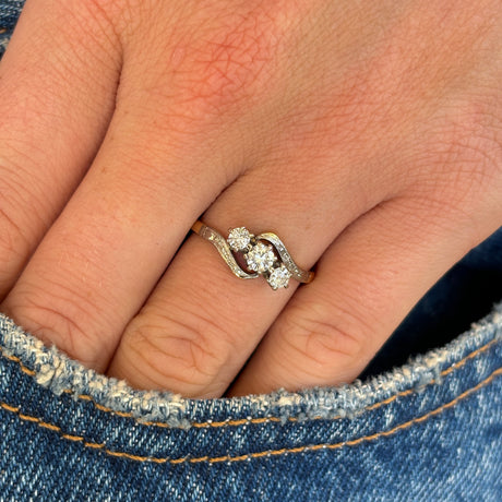 Antique, Edwardian three-stone diamond twist ring worn on hand.