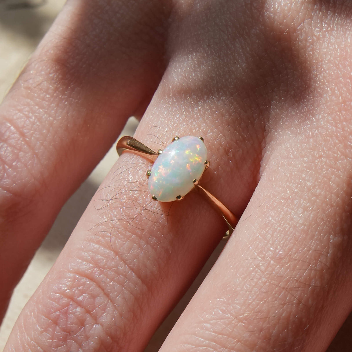1990s opal solitaire ring with iridescent gemstone in gold setting
