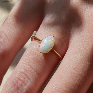 1990s opal solitaire ring with iridescent gemstone in gold setting