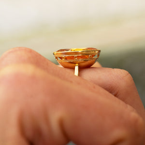Antique topaz ring showing raised gold setting and detailed band.