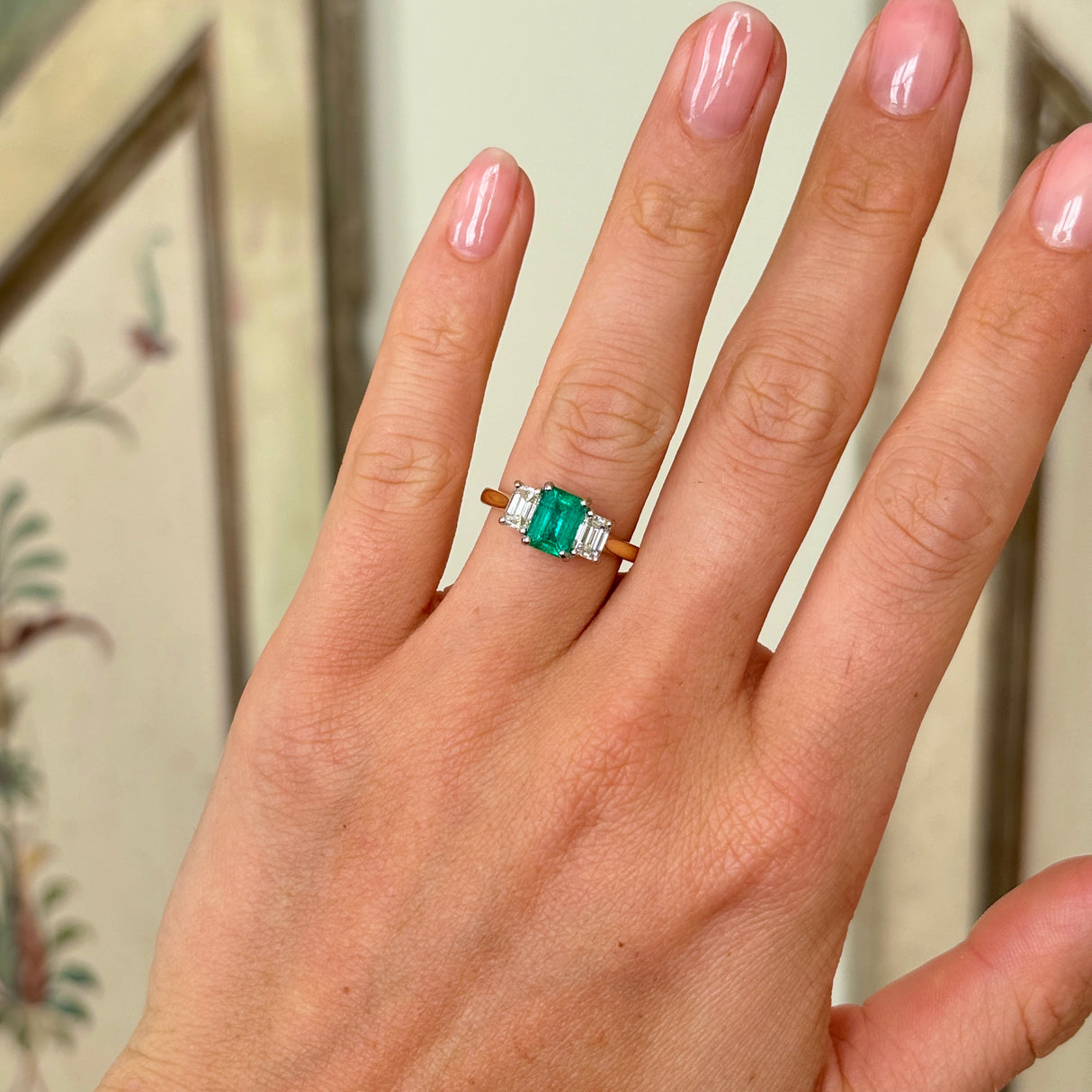 Vintage Emerald & diamond three-stone ring worn on hand. 