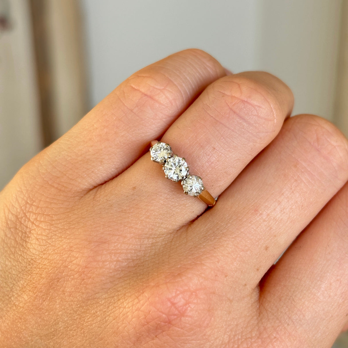 Vintage, 1970s three-stone diamond ring worn on hand.
