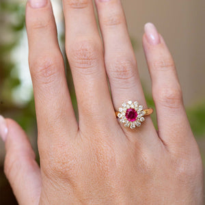 A vintage 1980s Burmese ruby and diamond cluster ring worn on the hand.