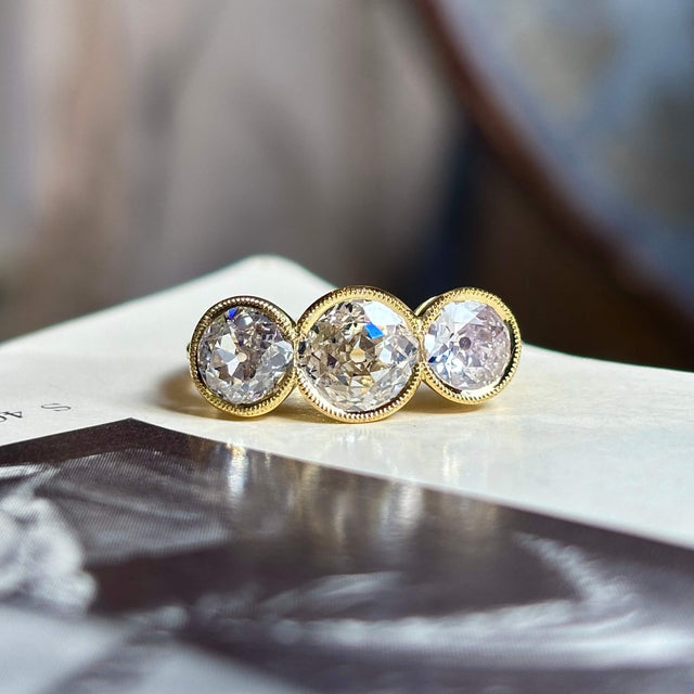 Antique, Victorian three-stone diamond ring shot on a vintage book with a blurred background