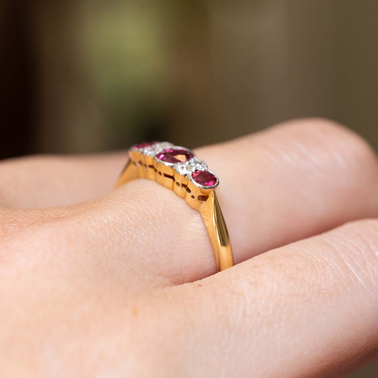 Side view of an antique Edwardian ruby and diamond five-stone ring in yellow gold.