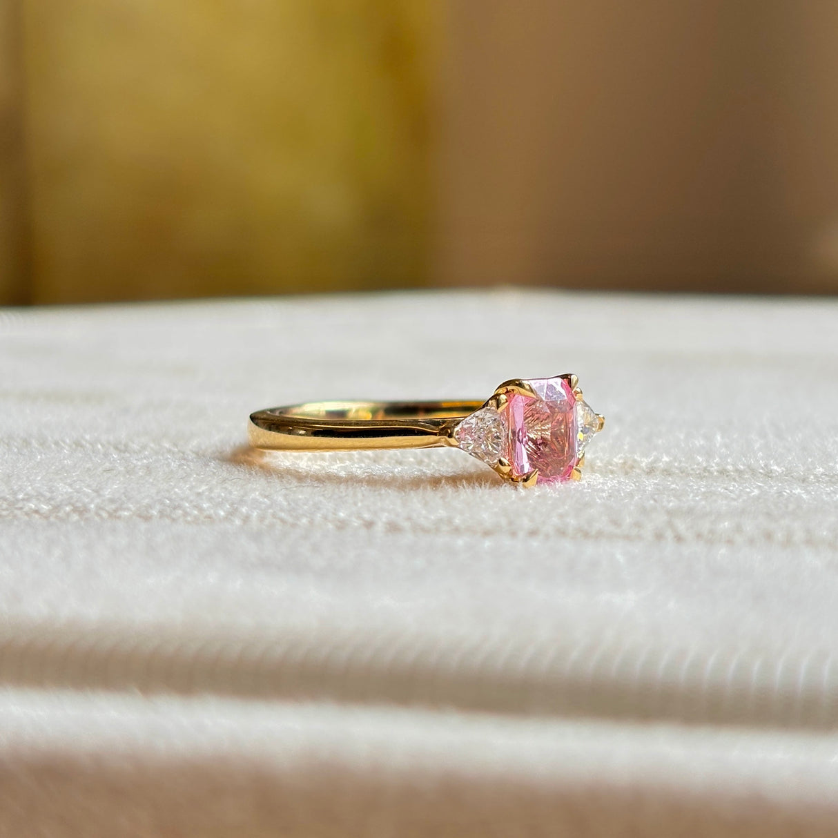 Pink sapphire and diamond three-stone engagement ring