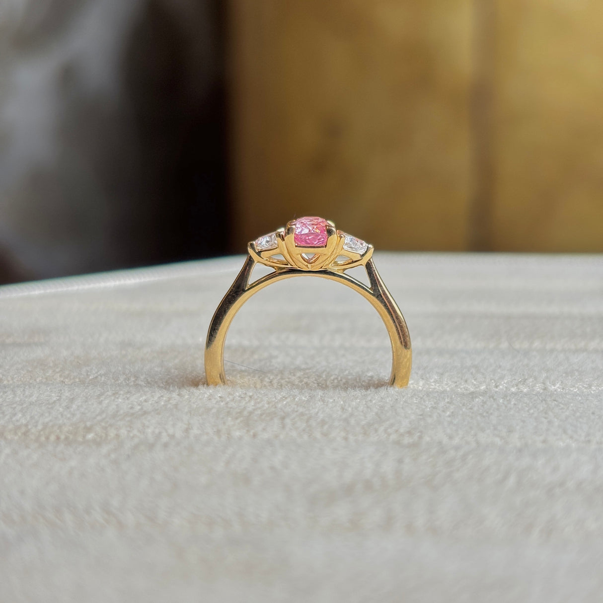 Pink sapphire and diamond three-stone engagement ring