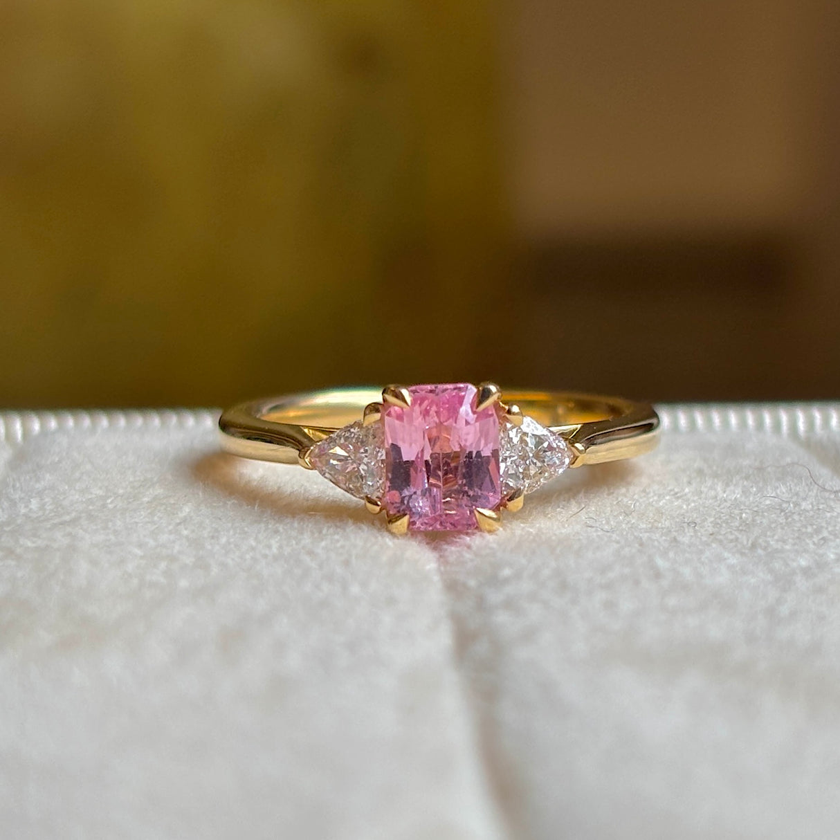 Pink sapphire and diamond three-stone engagement ring