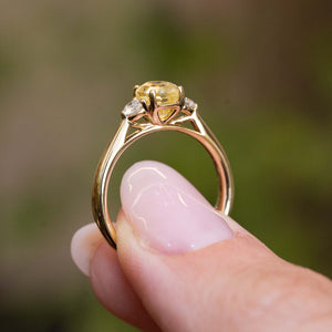 Gallery view of a vintage-inspired yellow gold ring featuring a yellow sapphire with diamond side stones.