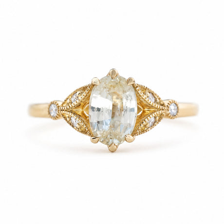 An antique-inspired, pale yellow sapphire & diamond engagement ring in yellow gold.