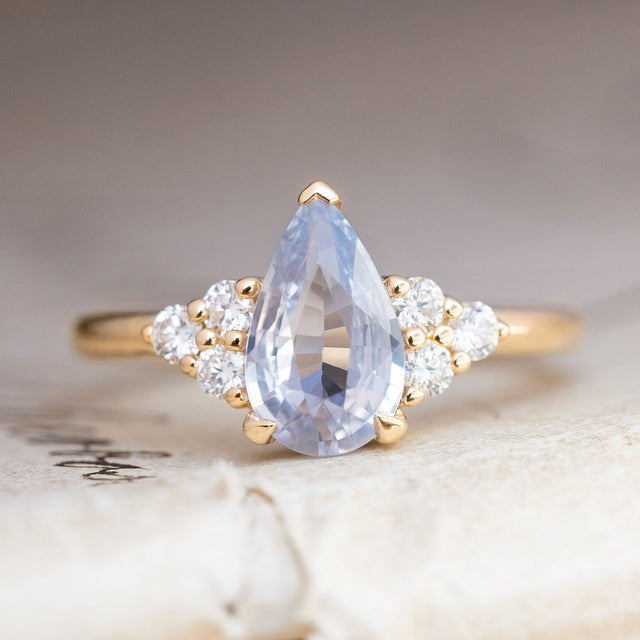A vintage-inspired white sapphire and diamond cluster tre-foil engagement ring in yellow gold. 