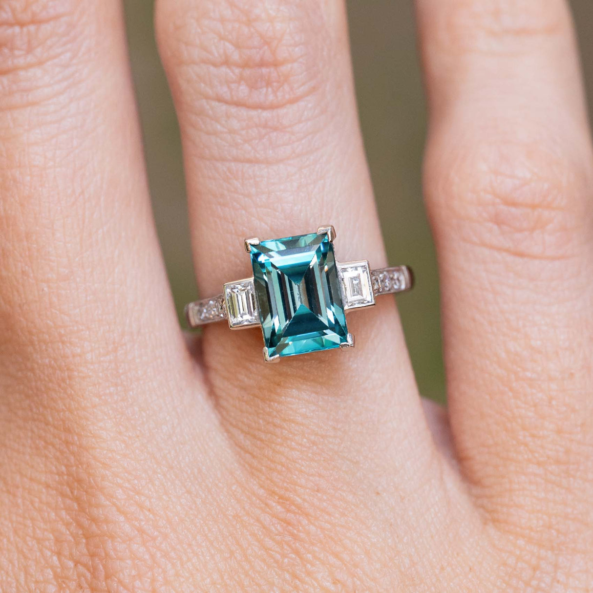 An antique Art Deco 1920s zircon and diamond ring worn on the finger.