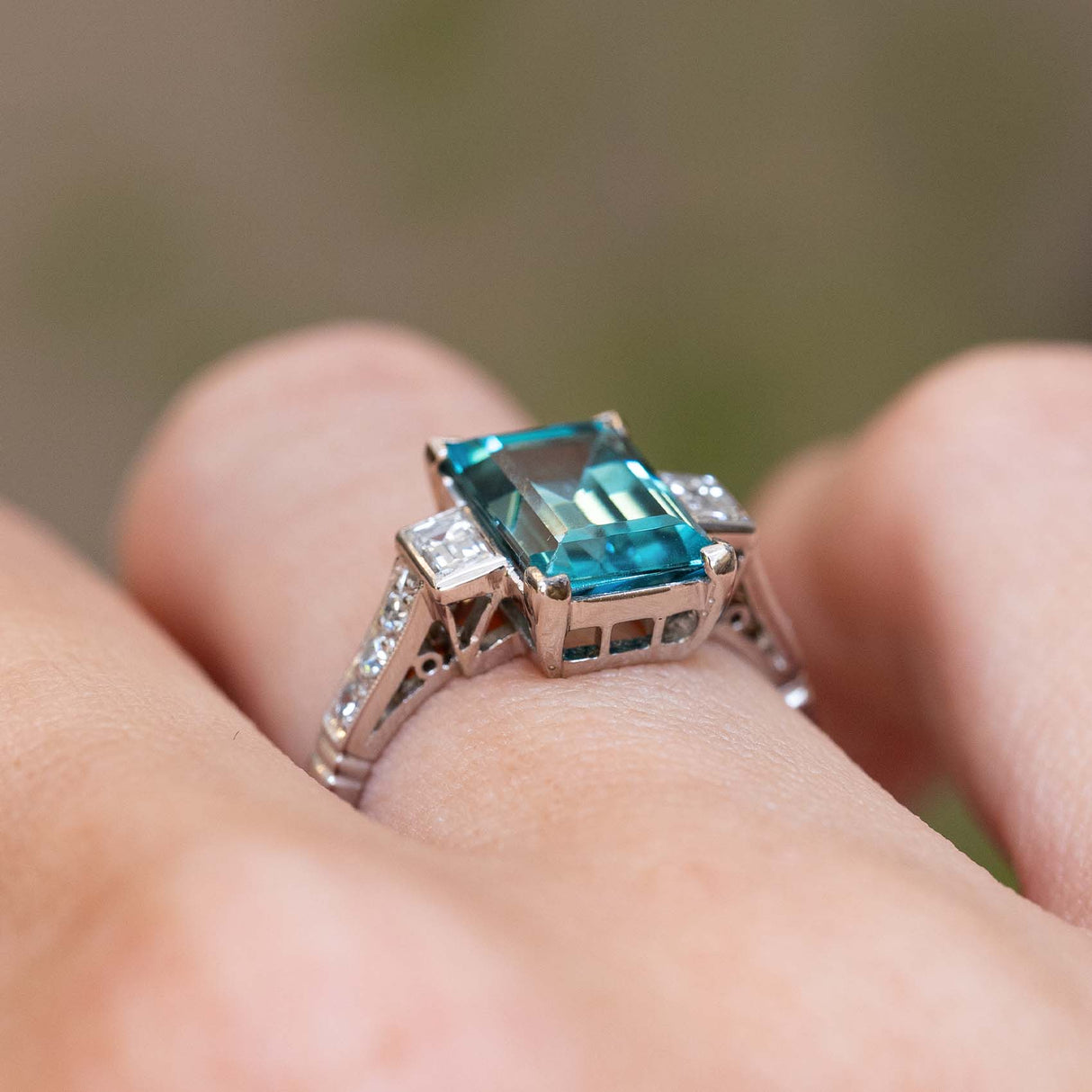 Side view of an antique Art Deco 1920s zircon and diamond ring worn on the finger.