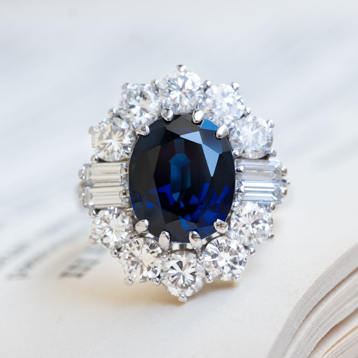 A Vintage ring from the 1960s with a large oval blue sapphire & diamond cluster halo.