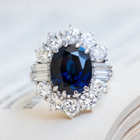 A Vintage ring from the 1960s with a large oval blue sapphire & diamond cluster halo.
