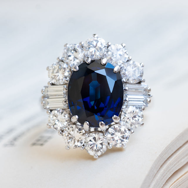 A Vintage ring from the 1960s with a large oval blue sapphire & diamond cluster halo.