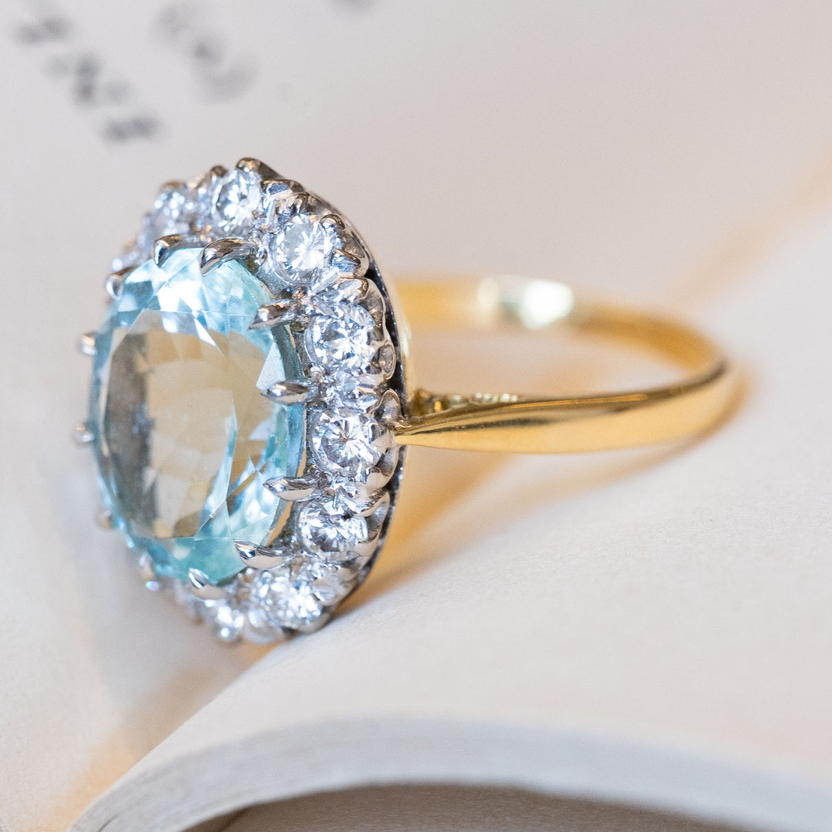 A vintage aquamarine & diamond halo cluster engagement ring in gold and platinum.